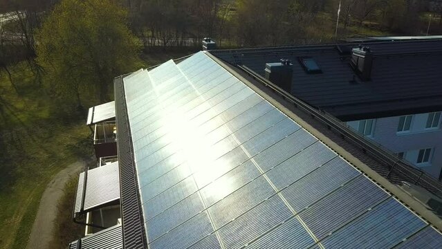 Renewable electricity development. Solar photovoltaic panels mounted on roof of swedish condo building in Linkoping residential area