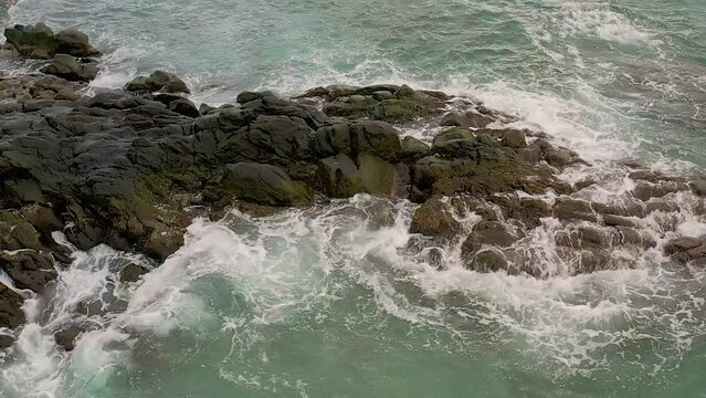 Ocean waves hit against rocky shoreline at Looc Beach, Surigao, Philippines