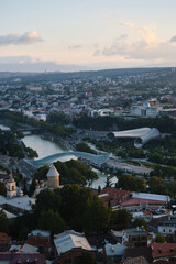 Morning view of the capital of Georgia - Tbilisi. Roofs of houses, churches and skyscrapers. View from a height from the fortress of the old town.