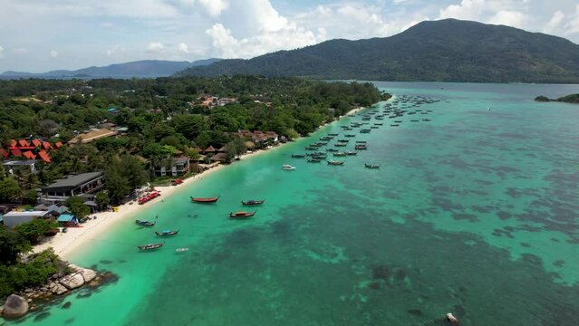 Koh Lipe Thailand Coastline, with boats and hotels, Ko Adang island in background- arial fly in