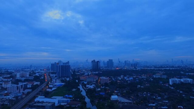 Timelapsed Rooftop View Of Downtown Bangkok At Blue Hour; Cars Moving Up And Down Major Roads.