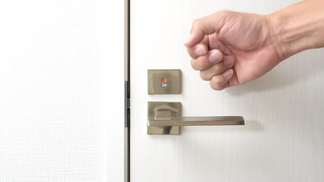 トイレのドアをノックする男性の手元