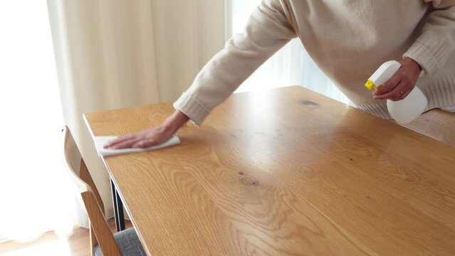 ダイニングテーブルを拭き掃除する女性