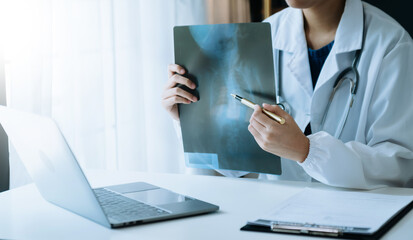  woman doctor showing x-ray lap sheet and explain the details to patient via video call system at...