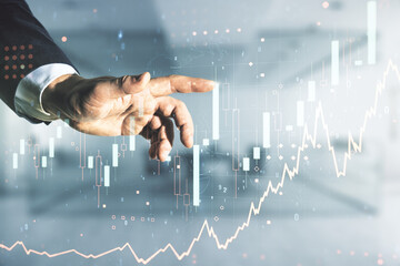 Double exposure of man hand clicks on abstract creative financial chart hologram on blurred office...