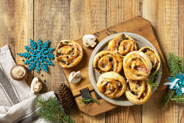 Italian appetizers. Pizza rolls puff pastry stuffed with prosciutto bacon, mushrooms and cheese on the Christmas table. View from above. Copy space. - obrazy, fototapety, plakaty