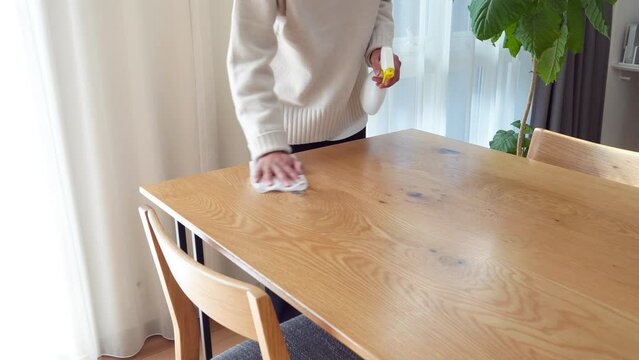 ダイニングテーブルを拭き掃除する女性