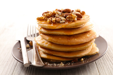 Homemade american pancakes with dried nuts and syrup