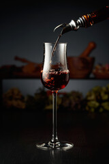 Brown herbal liquor or rum is poured from a vintage bottle.