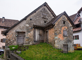 Fototapeta na wymiar An old derelict stone residential building in the historic mountain village of Rigolato in Carnia, Friuli-Venezia Giulia, North East Italy