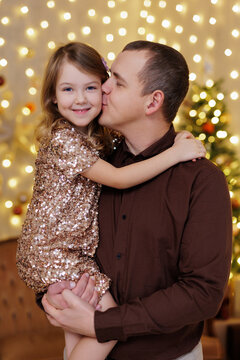 Father holding and kissing little daughter in cheek