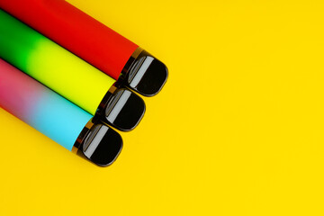 Fototapeta Colorful disposable electronic cigarettes on yellow background obraz