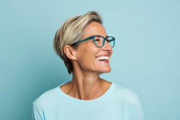 Portrait of happy young woman in eyeglasses on blue background - obrazy, fototapety, plakaty