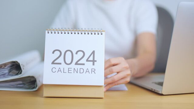 2024 Year Calendar on table with business woman using laptop computer. countdown, Happy New Year, Resolution, Goals, Plan,  Action, Mission and financial Concept
