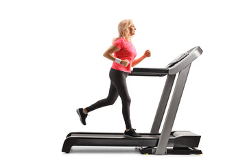 Full length profile shot of a mature woman running on a treadmill