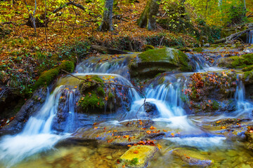 small waterfall on river flow through the mountain canyon, autumn mountain river scene