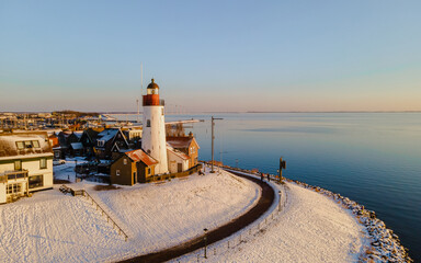 sunset at the Lighthouse of Urk Netherlands during winter with snow in the Netherlands. - obrazy, fototapety, plakaty
