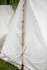 The tarpaulin for the tent is white, old fabric. - obrazy, fototapety, plakaty