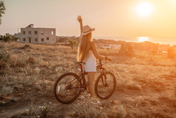 Woman travel bike. Happy woman cyclist sitting on her bike, enjoying the beautiful mountain and sea...