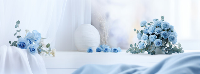白の机と壁紙に青い薔薇とユーカリを飾っている花瓶