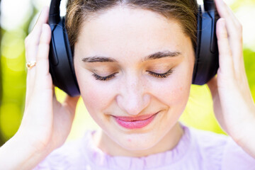 Discover the serene beauty of a young woman immersed in the world of music amidst the tranquility...