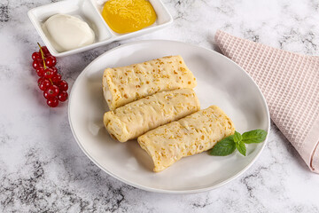 Homemade stuffed pancakes with honey and cream sour