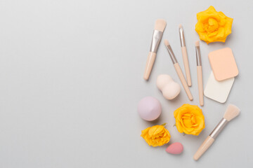 Makeup brushes and sponges on color background, top view