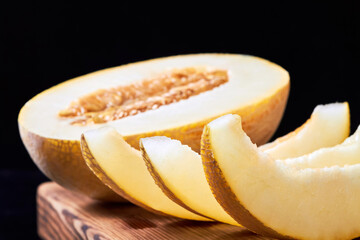 Close-up of melon slices and melon halves on a wooden board