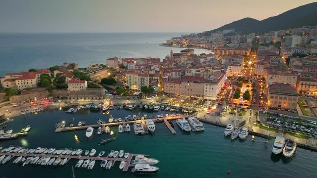Corsica island, aerial evening shot of Ajaccio old town. Flying over harbor, old houses and city lights in Ajaccio - capital of Corsica, France