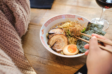 Faceless person enjoying delicious ramen