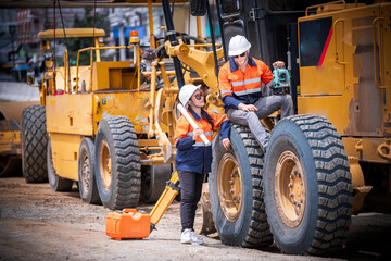 Engineer surveyors wearing uniform conversation on truck and blueprint check inspection by...