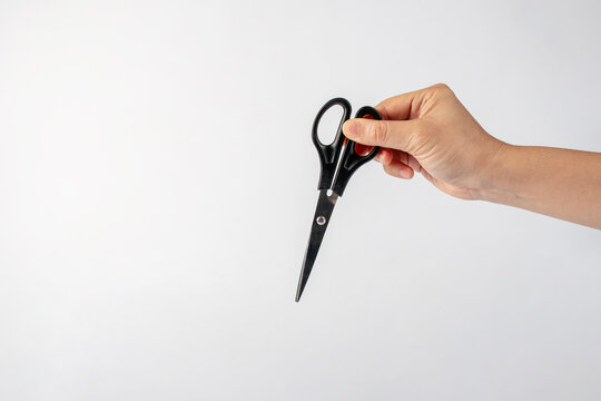 Stationery scissors in hand isolated on white background.
