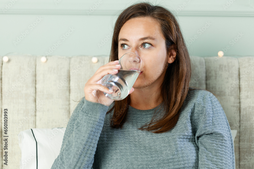 Wall mural Woman drinking water at home