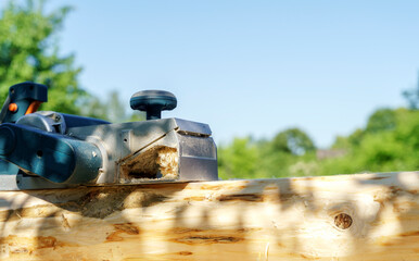 a carpenter works with an electric pipe on a sunny day