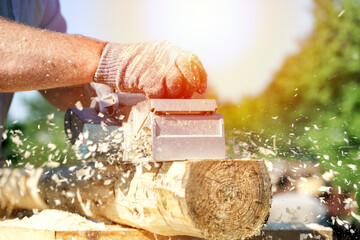 a carpenter works with an electric pipe on a sunny day