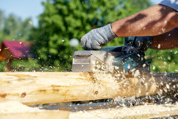 a carpenter works with an electric pipe on a sunny day