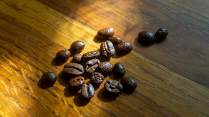 Coffee beans. Coffee beans in sunlight. Coffee beans on a wooden surface