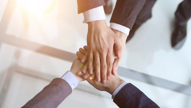 Cropped topview of businesspeople putting their hands. Conception of successful teambuilding