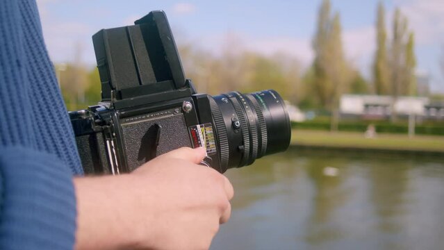 Photographer Holding Mamiya RB67 Analog Film Camera By The River In Amsterdam, Netherlands. closeup
