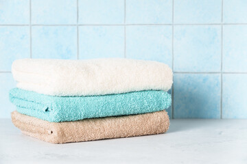 Obraz na płótnie Canvas Clean towels in the laundry or bathroom against blue wall.