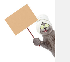 Happy cat with towel on it head shows empty placard behind empty white banner. isolated on white background