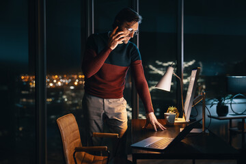 Business communication at night: Businessman discussing project on phone in office