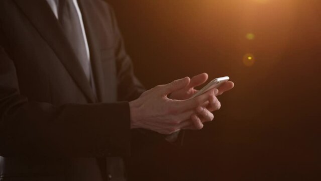 Side view of a man's hand presses a finger on a smartphone. Mock up for your design, copy space.