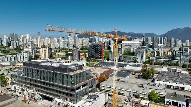 Tower Crane Operating At Development Site In Vancouver, Canada. aerial ascend