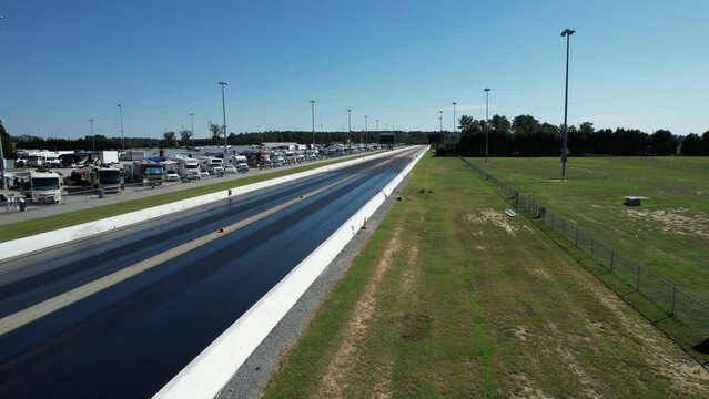 Wide drone shot of drag strip race track with RV's in background