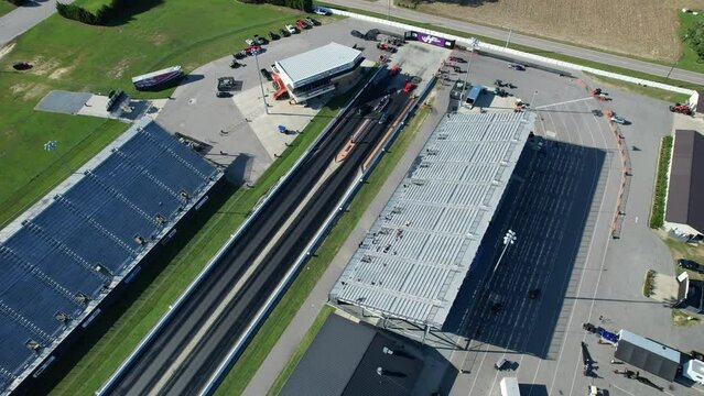 Wide drone shot of drag strip race track with stands
