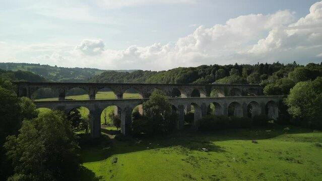 Chirk Aqueduct and Railway Viaduct approach, people crossing canal towpath - aerial drone fly forward and valley reveal - Welsh, English border, Sept 23