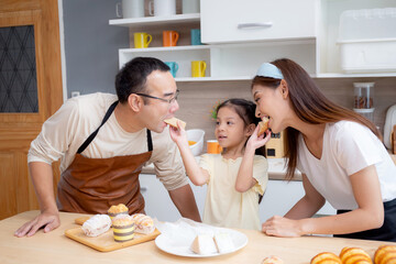 Happy family with father, mother and daughter in kitchen eating sandwich for healthy together at home, happiness mom, dad and child with bonding and relation, lifestyles and nutrition concept.
