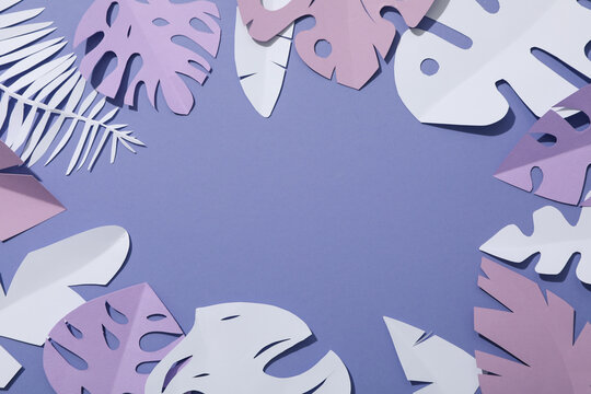 Purple, tropical leaves in pastel shades with space for text.