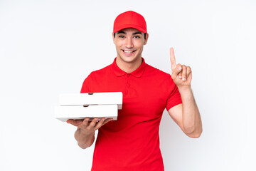 Pizza delivery caucasian man with work uniform picking up pizza boxes isolated on white background pointing up a great idea